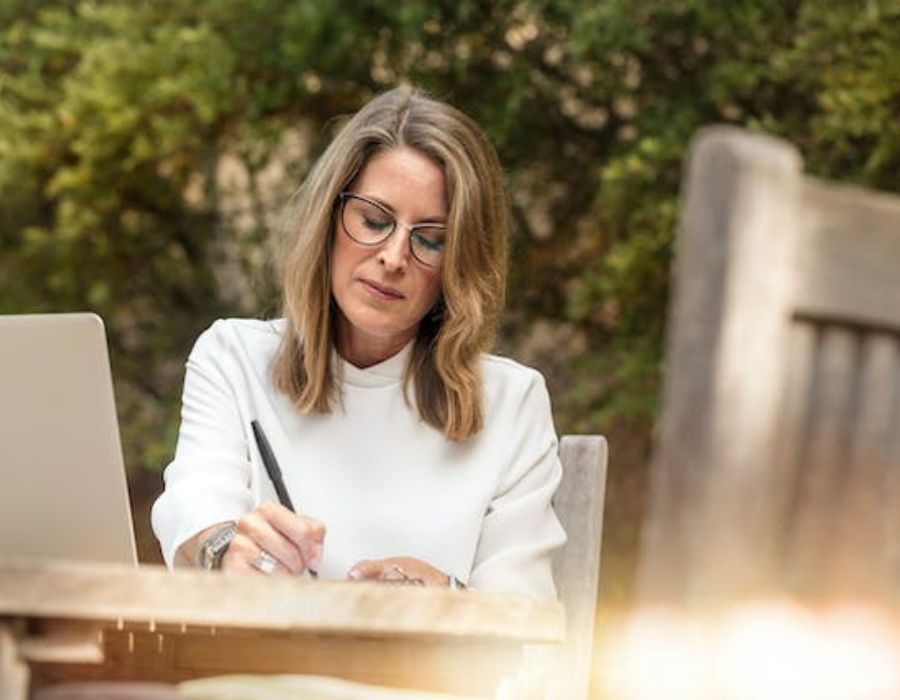 a woman writing down a Funeral service planning checklist