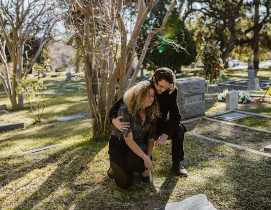 A Man and Woman Crying in the Cemetery