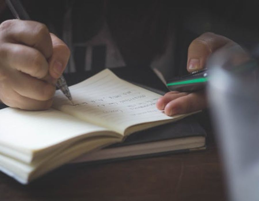 Person Writing While Using Phone