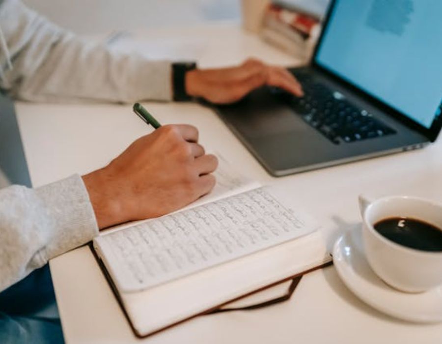 a man writing down on a piece of paper