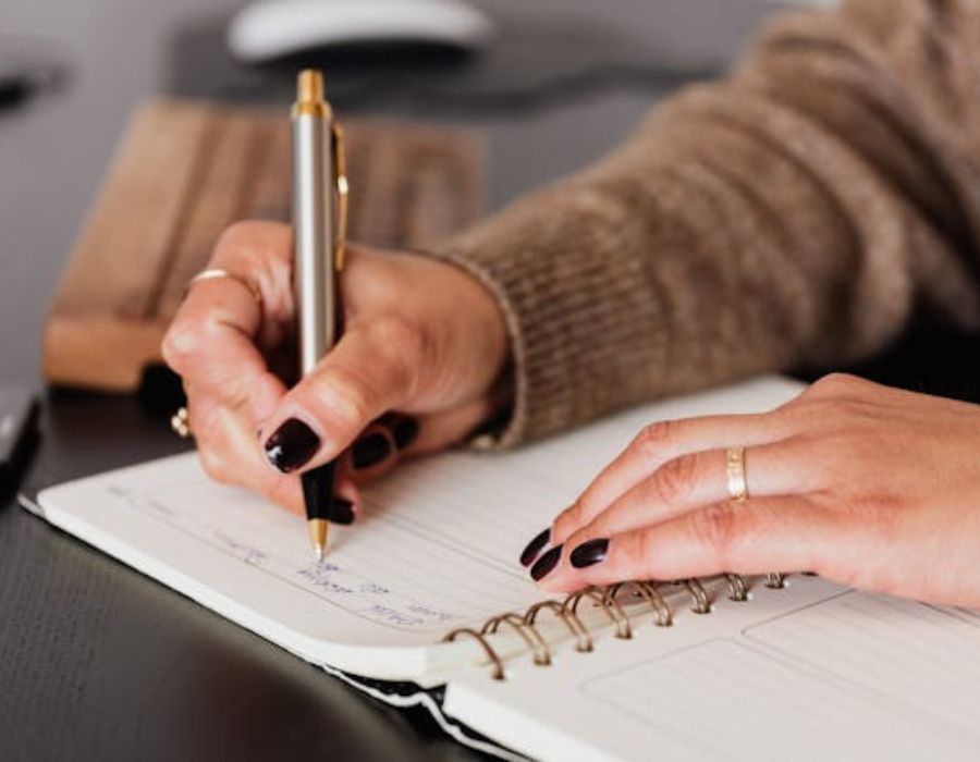 a woman writing on a piece of paper