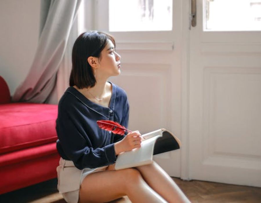 a thoughtful woman writing down something