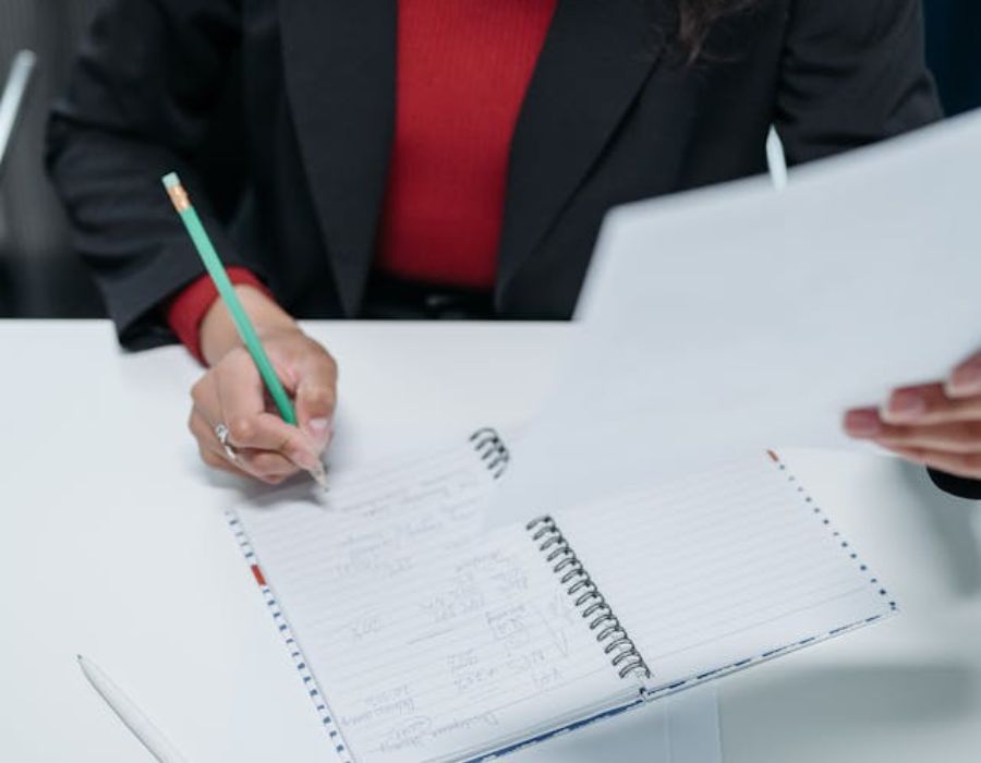 a woman writing something in a note book