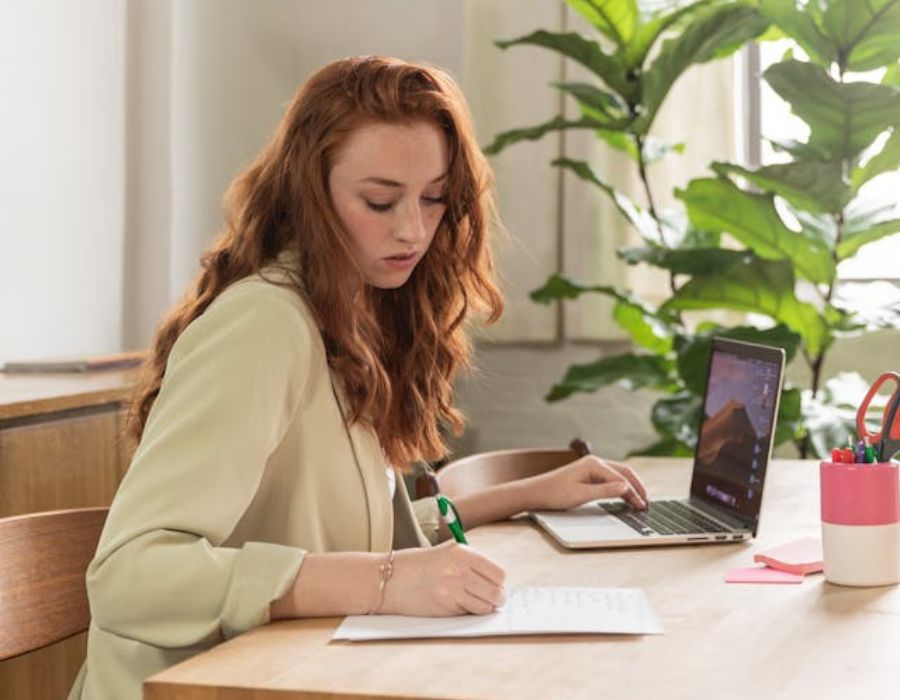 a woman typing while writing