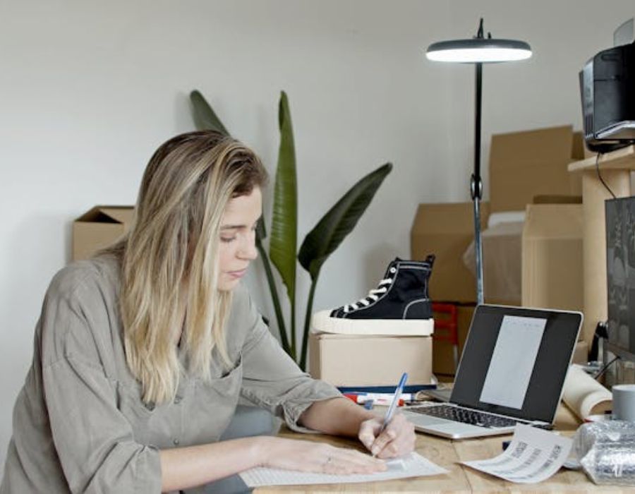a woman writing something on a piece of paper